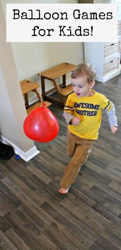 a young boy is playing with a red balloon