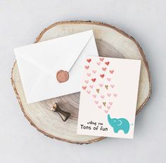 an envelope and stamp sitting on top of a piece of wood with hearts coming out of it