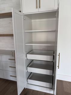 an empty pantry with white cupboards and drawers