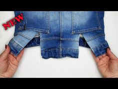 two hands holding up an old pair of jeans