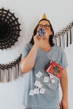 a man wearing a party hat and holding something in front of his face while surrounded by magnets