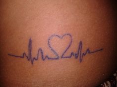 a woman's stomach with a heartbeat tattoo on it