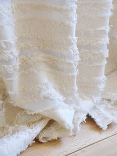 white linens are stacked on top of each other