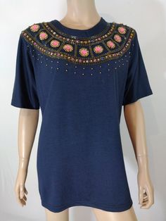 "80's Women's Shirt Short Sleeve T-Shirt Geometric Blue Pink Gold Beading 3D Rhinestone Jewels Shoulder Pads Rare Vintage by LIVE ME FASHIONS Size L Cool Unique Standout! This super cute RARE T-SHIRT top is fun to wear. Gorgeous navy blue 100% cotton t-shirt with shoulder pads, dramatic 80's silhouette, large round 3D faceted neon pink jewels, gold metallic beading, large and small sounded gold beads in a geometric design, COOL VINTAGE LABEL. Great with shorts, skirts, or jeans. Super high quali Embellished Short Sleeve T-shirt For Party, Beaded Short Sleeve Tops For Spring, Beaded Short Sleeve Tops For Summer, Spring Beaded Short Sleeve Top, Blue Embellished Short Sleeve Top, Blue Embellished Top With Short Sleeves, Carrie White, Pink Jewels, Shorts Skirts