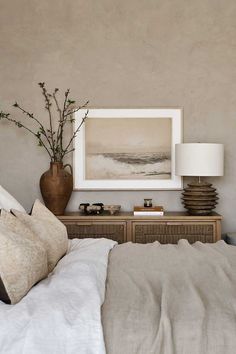 a bedroom with a bed, nightstand and painting on the wall