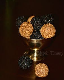 a metal bowl filled with fruit sitting on top of a table next to two blackberries