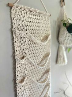 two crocheted wall hangings are hung on the wall next to a potted plant