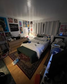 a bedroom with a bed, dresser and bookshelf