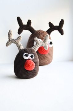 two crocheted reindeer slippers sitting next to each other on a white surface