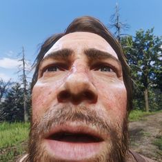 a man with freckles on his face looking up at the sky and trees