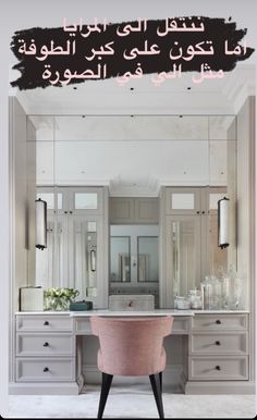 a pink chair sitting in front of a bathroom mirror with writing on the wall above it