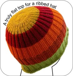 a knitted hat with multicolored stripes on the top and bottom, as well as words above it