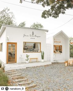 a small white building sitting on top of a gravel field