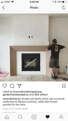 a man is standing in front of a fireplace with his hands on the back of it