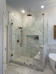 a walk in shower sitting next to a white bath tub