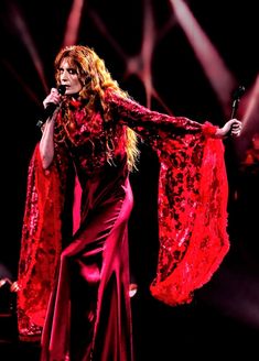 a woman in a red dress holding a microphone