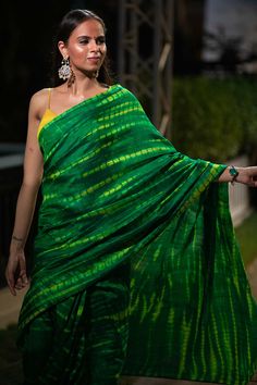 Upgrade your ethnic elegance with our Gia Green & Yellow Tie Dye Georgette Silk One Minute Saree. Crafted from luxurious raw silk, this stunning saree features a mesmerizing green-yellow tie-dye pattern. The pallu is adorned with vibrant yellow tassels, while the matching blouse comes with delicate spaghetti straps in yellow raw silk, adding a touch of sophistication to your traditional attire. Suitable for a summer night out, wedding party, pooja or any other function! About this Product Saree: Green Chanderi Pre-draped Saree For Festivals, Green Chanderi Pre-draped Saree For Puja, Green Pre-draped Saree With Self Design For Diwali, Transitional Green Pre-draped Saree With Self Design, Green Raw Silk Pre-draped Saree With Self Design, Green Tussar Silk Pre-draped Saree With Dupatta, Green Slub Silk Pre-draped Saree For Diwali, Designer Green Saree For Transitional Season, Festive Green Designer Saree