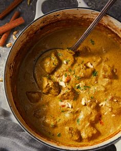 a pot filled with curry and chicken on top of a table