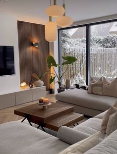 a living room filled with furniture and a flat screen tv mounted on the wall above it