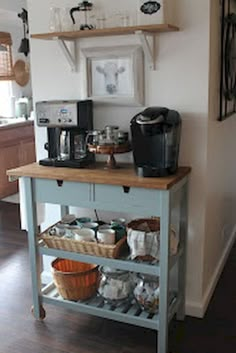 a kitchen island with coffee maker and cups on it