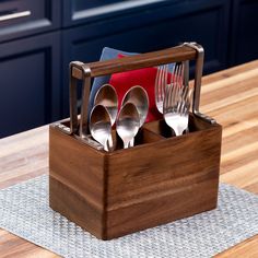 a wooden box with utensils and spoons in it on top of a table