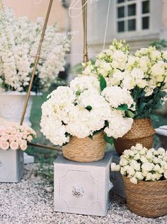 white flowers are in baskets on the ground