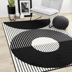 a black and white area rug with an abstract design on the floor next to a chair