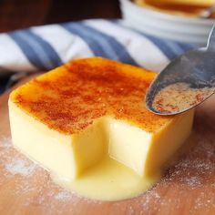 a piece of cheese is being spooned into it with a small bowl in the background