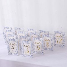 blue and white place cards with gold numbers