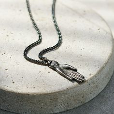 This is a striking men's necklace featuring an oxidised sterling silver pendant in the shape of an outstretched hand. The pendant has a rugged, antiqued finish that gives it a vintage, artisanal feel, adding to its masculine appeal. The hand is detailed yet understated, making it a versatile piece that can be worn as a statement accessory.   The pendant hangs from a matching Sterling silver oxidised curb chain, which complements the overall rugged aesthetic of the necklace. This piece is ideal f Symbolic Sterling Silver Necklace With Antique Finish, Outstretched Hand, Rugged Aesthetic, Hamsa Hand Necklace, The Hand Of God, Posh Totty, Hand Pendant, Hand Of God, Hand Necklace