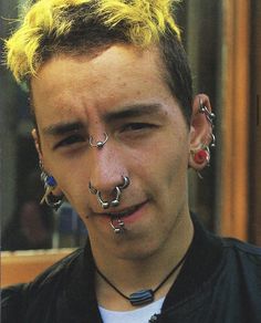 a man with piercings on his face and nose