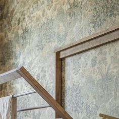 an old fashioned wooden bed frame in front of a wallpapered background