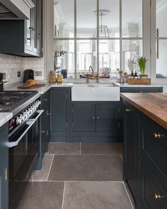 a kitchen with dark blue cabinets and white counter tops