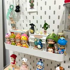 there are many toy figurines on the shelf in this room, including little people