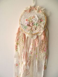 a white wall hanging with flowers and lace