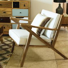 a white chair sitting in front of a wooden dresser