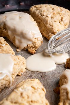 a whisk is being used to make scones with frosting on them