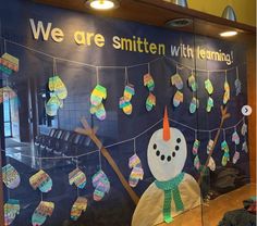 a bulletin board that has been decorated with paper snowmen and words we are smitten with learning