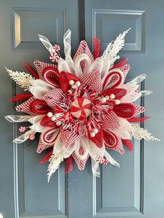 a red and white wreath hanging on the front door