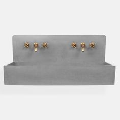 a sink with three gold knobs on the front and two small brass knobs on the back