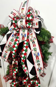 a christmas wreath with red, white and green ribbons