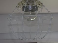 a light fixture hanging from the ceiling in a room with white walls and wood floors