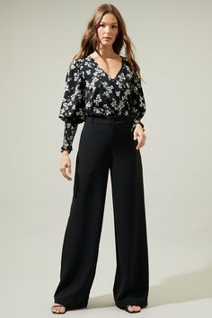 Transition through the seasons in style with the Kennie Floral Smocked Long Sleeve Blouse! This gorgeous black and white floral print shapes this top that has a v-neckline and bouncy long sleeves with elastic smocked cuffs. Easy to wear with any pants to match the floral print and some flats for a comfy yet stylish look. - V-neck- Smocked cuffs- Relaxed fit- Puff sleeves- Color: Black whiteSize + Fit - Model is 5'8" and wearing size XS- Measurements taken from size S - Chest: 18 1/2"- Length: 25 Versatile V-neck Blouse With Floral Print, V-neck Blouse With Elastic Sleeves For Work, Full Sleeve Top, Black And White Floral, The Seasons, Black Print, Black Blouse, Full Sleeve, Puff Sleeves