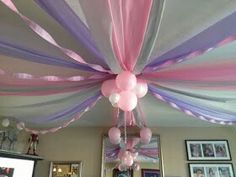 the ceiling is decorated with pink, purple and white streamers as well as balloons