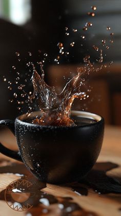 a black cup with water splashing out of it on top of a wooden table