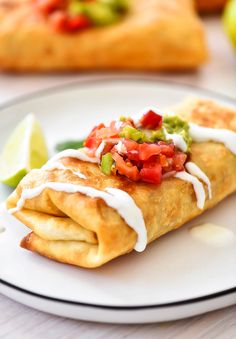 a white plate topped with two tacos covered in toppings