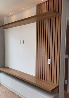 an empty room with wood paneling on the wall and wooden shelves in front of it