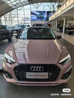 a pink car is parked in a showroom