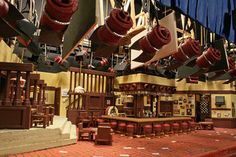 the interior of a restaurant with red brick flooring and lots of wooden chairs hanging from the ceiling