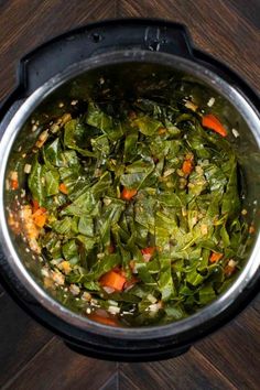 a pot filled with vegetables on top of a wooden table